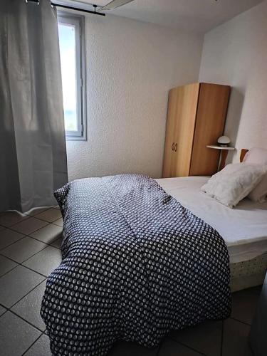 une chambre avec un lit avec une couette noire et blanche dans l'établissement Résidence Palmyra - Appartement 2 pièces 4 couchages LE BARCARES MAE-5754, au Barcarès