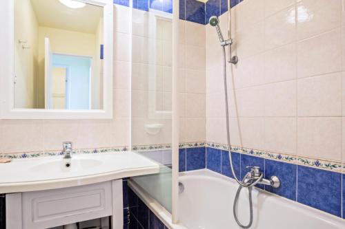 een badkamer met een bad, een wastafel en een douche bij Résidence le Hameau des Issambres - maeva Home - 2 pièces 6 personnes Séle 37 in Les Issambres