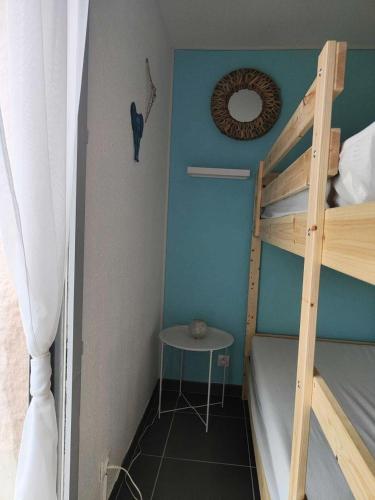 Cette petite chambre comprend des lits superposés et une table. dans l'établissement Résidence Antigua - Appartement 2 pièces 4 couchages LE BARCARES MAE-5434, au Barcarès