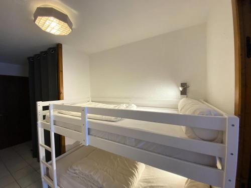 Cette chambre comprend deux lits superposés et une lampe. dans l'établissement Residence Tigny - 2 pièces cabine 4 personnes exposé sud MAE-8754, à Valloire