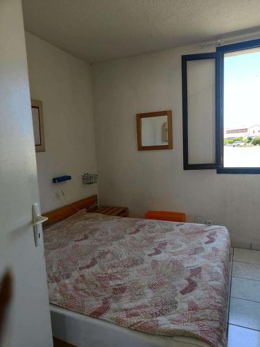 une chambre avec un lit et une fenêtre dans l'établissement Résidence Bar054-le Barcares - Appartement 2 pièces au rez-de-chaussée à LE BARCARES - CAP COUDALERE MAE-1664, au Barcarès
