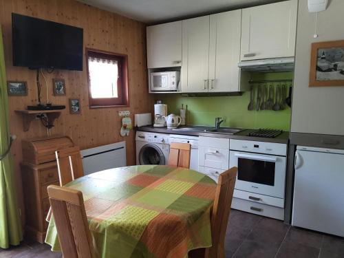 une cuisine avec une table et des placards blancs dans l'établissement Résidence La Croix Du Sud - Studio cabine 4 personnes 2 exposé Est MAE-8784, à Valloire