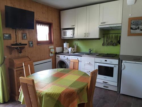 a kitchen with a table and a kitchen with white cabinets at Résidence La Croix Du Sud - Studio pour 4 Personnes 84 in Valloire