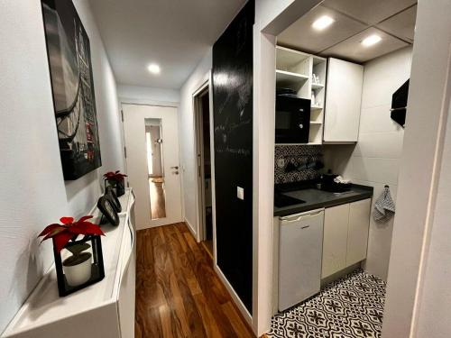 eine kleine Küche mit weißen Schränken und einer schwarzen Arbeitsplatte in der Unterkunft Charming apartment in Cártama, 30 m² with terrace in Cártama