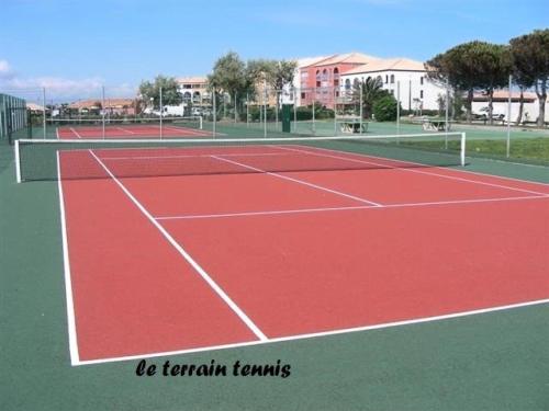 a tennis court with two tennis courts at Résidence Palmyra - 2 Pièces pour 4 Personnes 414 in Le Barcarès