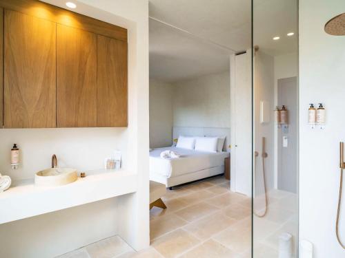 a bathroom with a bed and a glass shower at Mercure Benidorm in Benidorm