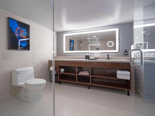 a bathroom with a sink and a toilet and a mirror at Hilton Garden Inn San Juan Condado in San Juan