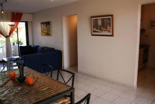 een woonkamer met een tafel en een bank bij Résidence Bd Guadeloupe - 3 Pièces pour 6 Personnes 464 in Le Barcarès