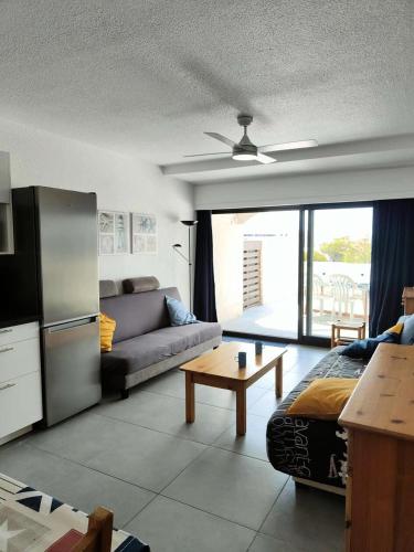 un salon avec un canapé et une table dans l'établissement Résidence Palmyra - Appartement T2 au rez-de-chaussée à LE BARCARES-CAP COUDALERE MAE-6904, au Barcarès