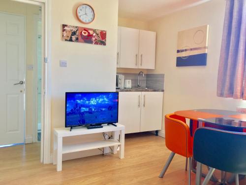 - un salon avec une télévision sur une table blanche dans l'établissement 1 Bed Apartment,Recep,Kitchen,Bath, à Ilford