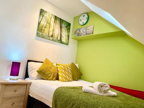 - une chambre dotée d'un lit avec un mur vert dans l'établissement 1 Bed Apartment,Recep,Kitchen,Bath, à Ilford