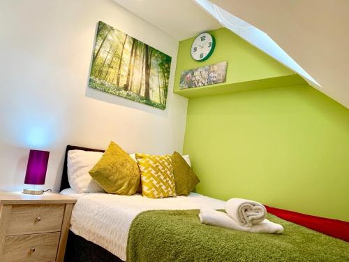 a bedroom with a bed with a green wall at 1 Bed Apartment,Recep,Kitchen,Bath in Ilford