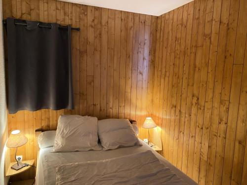 - une chambre avec des murs en bois et un lit avec deux lampes dans l'établissement Residence Tigny - 2 pièces cabine 4 personnes exposé sud est MAE-9034, à Valloire