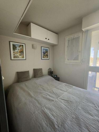 une chambre avec un grand lit et une fenêtre dans l'établissement Résidence Pointe Vermeille - Appartement T2 Cabine 6 pers- Les pieds dans l'eau MAE-3984, au Barcarès
