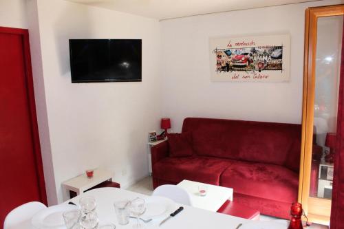 uma sala de estar com um sofá vermelho e uma mesa em Résidence La Croix Du Sud - Studio pour 4 Personnes 44 em Valloire