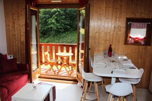 une chambre avec une table et des chaises ainsi qu'une terrasse couverte dans l'établissement Résidence La Croix Du Sud - Studio cabine 4 personnes 2 exposé est MAE-9044, à Valloire