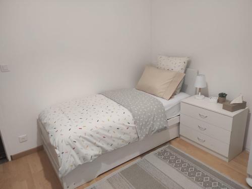a small bedroom with a bed and a nightstand at Chambres Senonches centre-ville in Senonches
