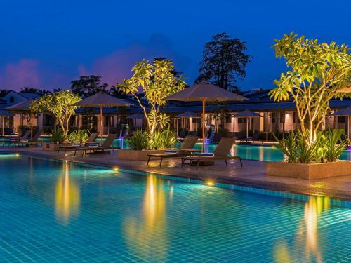 a pool at night with chairs and umbrellas at ibis Styles Sepang KLIA in Sepang