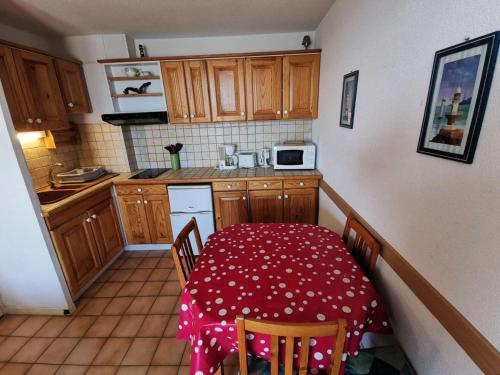 une petite cuisine avec une table et un chiffon rouge dans l'établissement Résidence Grande Bleue - 2 Pièces 4 couchages PORT LEUCATE MAE-4474, à Port-Leucate