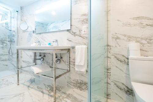 y baño con lavabo y ducha. en HL Rondo Hotel en Playa del Inglés