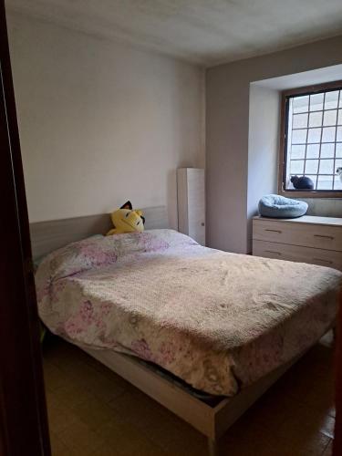 un dormitorio con una cama con un animal de peluche en Appartamento vacanze low cost tra lago idro e ledro, en Storo