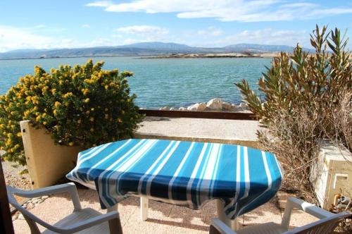 - une table et des chaises bleues et blanches sur la plage dans l'établissement Résidence Hawai 1 - VILLA T1 CAB MEZZ 5 couchages PORT LEUCATE MAE-4524, à Port-Leucate