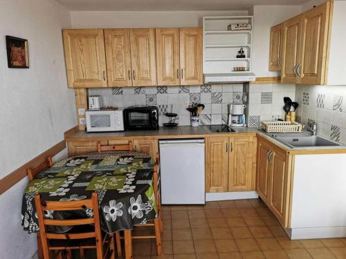 une cuisine avec des armoires en bois et une table avec des chaises dans l'établissement Résidence Grande Bleue - 2 Pièces 4 couchages PORT LEUCATE MAE-4454, à Port-Leucate