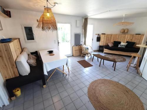 ein Wohnzimmer mit einem Sofa und einem Tisch in der Unterkunft Résidence ILE DES PECHEURS - Maisons & Villas pour 6 Personnes 64 in Port Leucate
