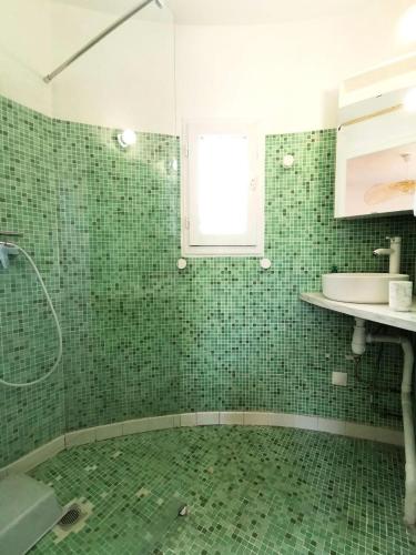 La salle de bains est pourvue de carrelage vert, d'une douche et d'un lavabo. dans l'établissement Résidence Ile Des Pecheurs - VILLA 3 PIECES 6 couchages LE BARCARES MAE-4464, à Port-Leucate