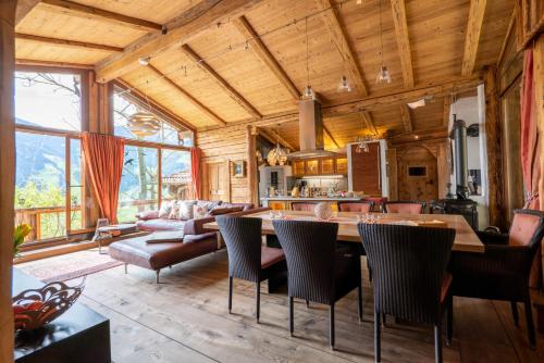 uma cozinha e sala de estar com mesa e cadeiras em Luxus Chalet Mühlermoos em Ramsau im Zillertal