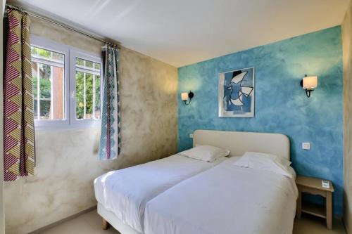 une chambre avec un lit blanc et une fenêtre dans l'établissement Les Issambres Corniche - maeva Home - Appartement 3 pièces 6 personnes vue mer - Prestige - super Home MAE-1208, aux Issambres