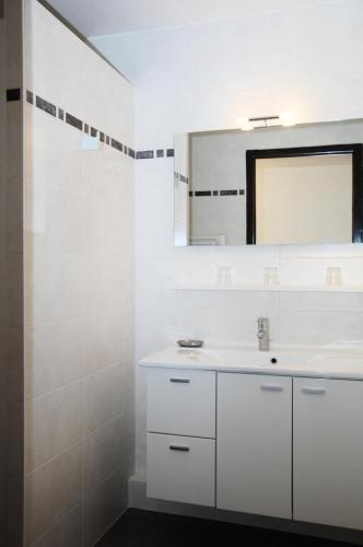 une salle de bain blanche avec un lavabo et un miroir dans l'établissement Résidence Le Praz - Studio cabine 4 personnes 2 exposé Sud MAE-9104, à Valloire