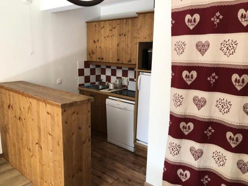 a kitchen with a red and white pattern on the wall at Les Chalets Valoria - 3 Pièces pour 6 Personnes 54 in Valloire