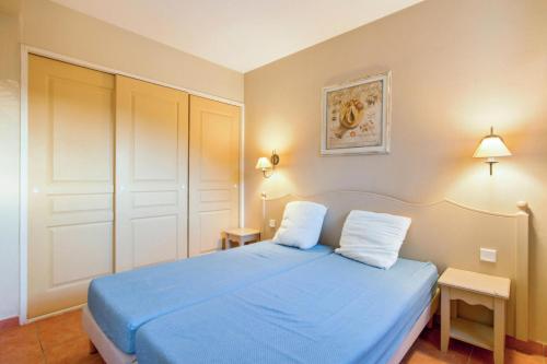 sypialnia z niebieskim łóżkiem i dwiema poduszkami w obiekcie Les Issambres Corniche - maeva Home - Appartement 2 pièces 5 personnes Confort MAE-1353 w mieście Les Issambres