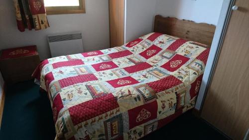 un lit avec une couette dessus dans une chambre dans l'établissement Edelweiss Chalets De La Vallee D'or - 2 pièces 4 personnes 3 exposé Nord MAE-9334, à Valloire