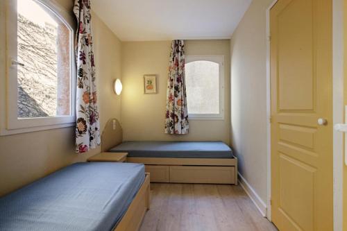 une petite chambre avec deux lits et une fenêtre dans l'établissement Les Issambres Bellevue - maeva Home - Appartement 3 pièces 6 personnes - Confort MAE-1364, aux Issambres