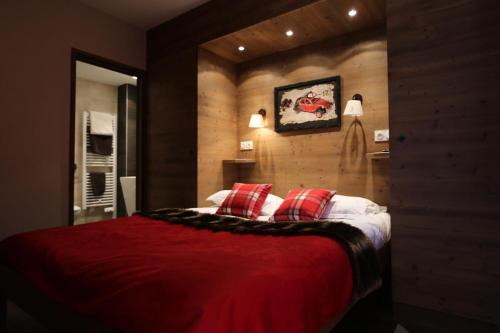 a bedroom with a large bed with red pillows at Les Chalets D'adrien - 4 Pièces pour 8 Personnes 44 in Valloire