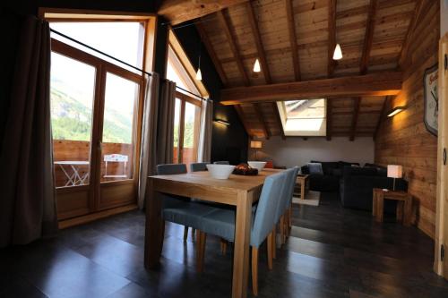 een eetkamer met een tafel en een bank bij Les Chalets D'adrien - 3 Pièces pour 6 Personnes 74 in Valloire