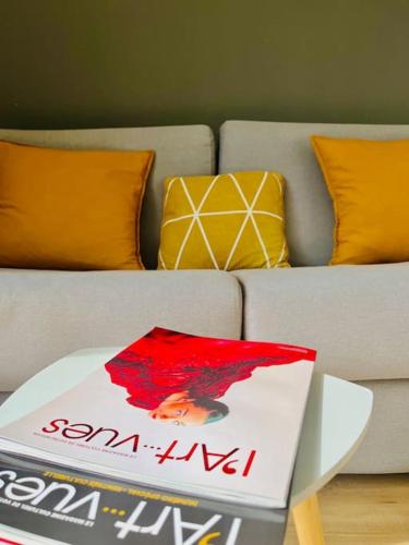 un livre assis sur une table à côté d'un canapé dans l'établissement ''Brave Margot'' Cosy T2 avec clim et terrasse, à Sète