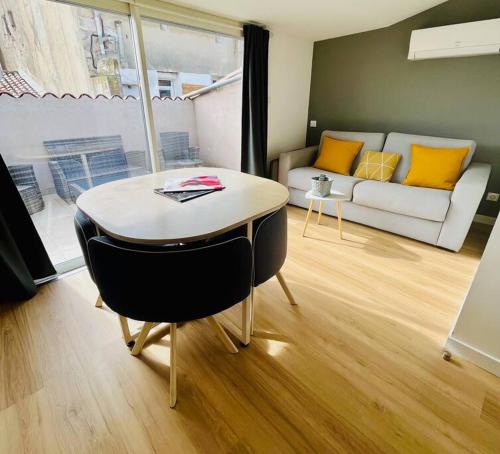 un salon avec une table et un canapé dans l'établissement ''Brave Margot'' Cosy T2 avec clim et terrasse, à Sète