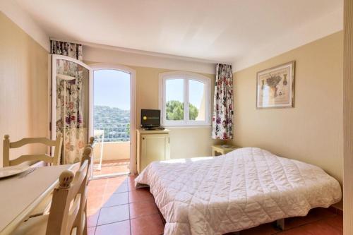 1 dormitorio con cama, escritorio y ventana en Les Issambres Lauriers - maeva Home - Studio 4 personnes Confort 77 en Les Issambres
