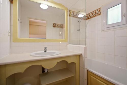 une salle de bain avec un lavabo, un miroir et une baignoire dans l'établissement Les Issambres Corniche - maeva Home - Appartement 2 pièces 6 personnes Sélection MAE-1357, aux Issambres
