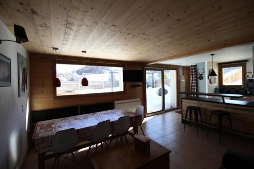 une pièce avec une table et des chaises et une cuisine dans l'établissement Chalet Le Tatihou - Appartement 6 personnes 3 exposé est MAE-9574, à Valloire