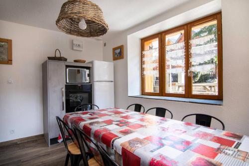 une cuisine avec une table, des chaises et un réfrigérateur dans l'établissement Chalet Gilbert Collet - 3 Pièces pour 8 Personnes 44, à Valloire