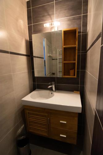 une salle de bain avec un lavabo et un miroir dans l'établissement Chalet Gilbert Collet - 3 Pièces pour 8 Personnes 44, à Valloire