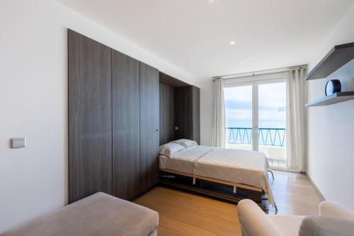 a bedroom with a bed and a large window at 2 bedrooms Duplex penthouse - Monaco border in Roquebrune-Cap-Martin