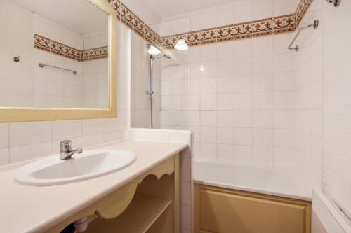 La salle de bains blanche est pourvue d'un lavabo et d'une baignoire. dans l'établissement Les Issambres Lauriers - maeva Home - Appartement 2 pièces 5 personnes Confort MAE-1800, aux Issambres