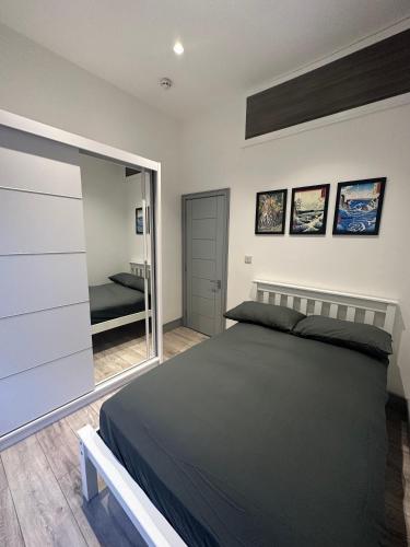 ein Schlafzimmer mit einem großen Bett und einem Spiegel in der Unterkunft Stylish and cozy flats in London