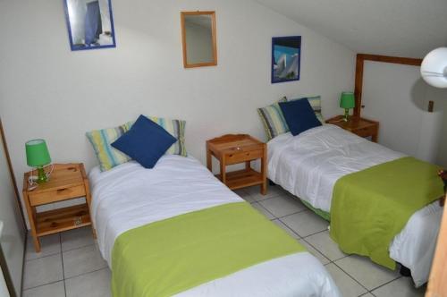 - une chambre avec 2 lits avec des draps verts et blancs dans l'établissement Résidence Grande Bleue - VILLA 3 PIECES 6 couchages PORT LEUCATE MAE-4804, à Port-Leucate