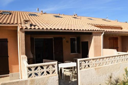 Cette maison dispose d'un balcon avec une table et un toit. dans l'établissement Résidence Grande Bleue - VILLA 3 PIECES 6 couchages PORT LEUCATE MAE-4804, à Port-Leucate